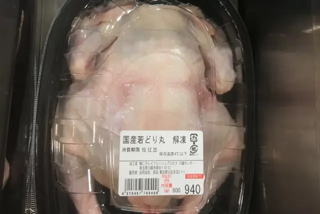 Whole raw chicken in a sealed retail tray with a printed label