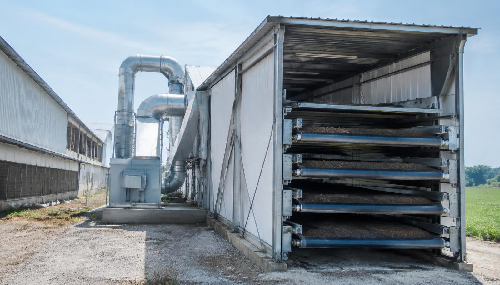 Multi-level manure drying tunnel beside a layer house using warm exhaust air
